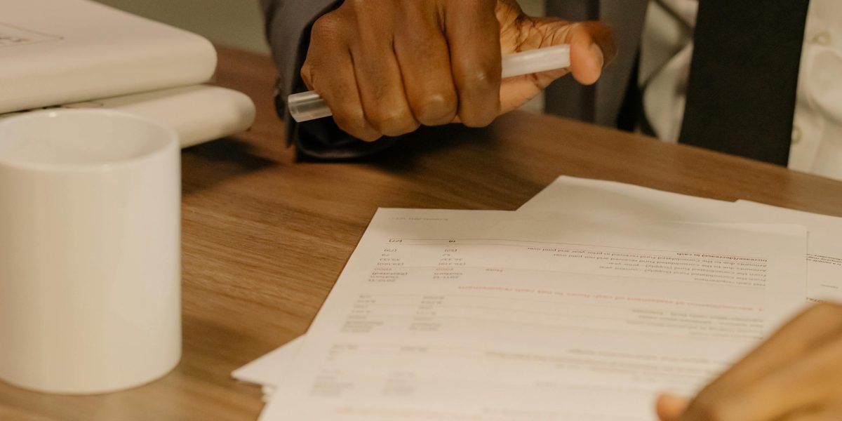 Individuals carefully reviewing property documents, emphasizing the critical step of due diligence before purchase.