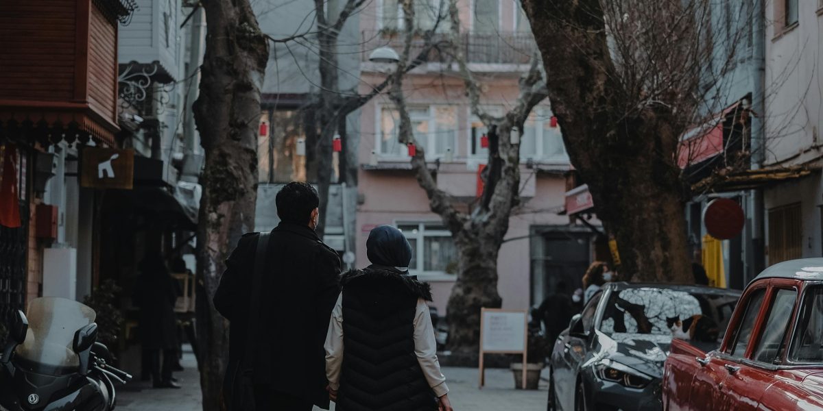 A couple explores a neighborhood, assessing amenities and connectivity for potential property investment.