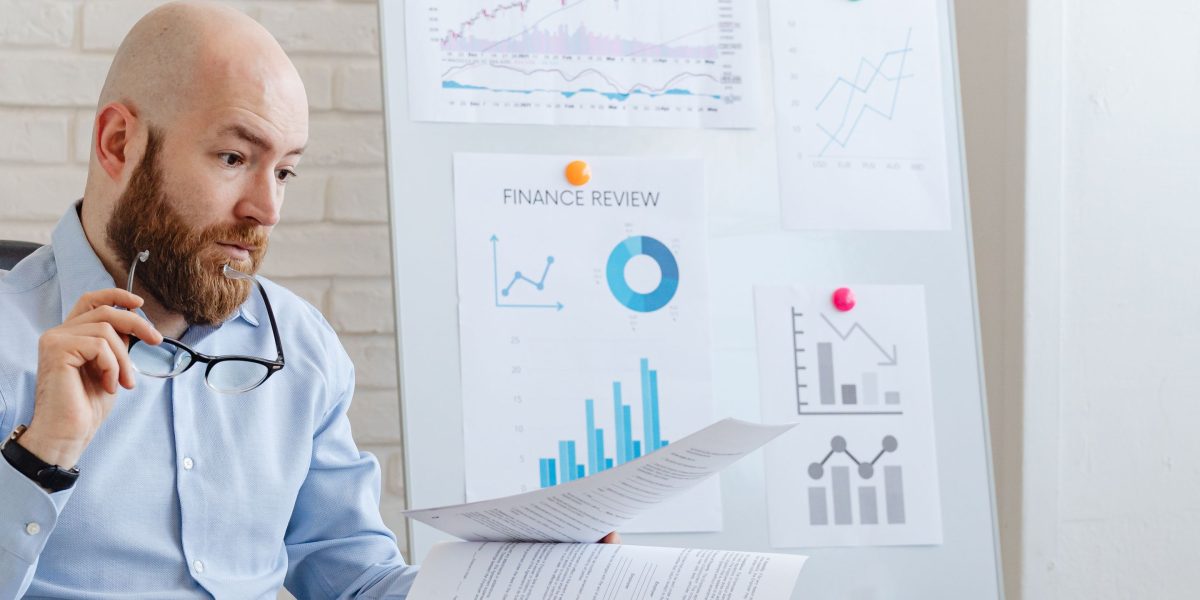 An investor deeply focused on analyzing financial reports and spreadsheets, crucial for due diligence in property investment.