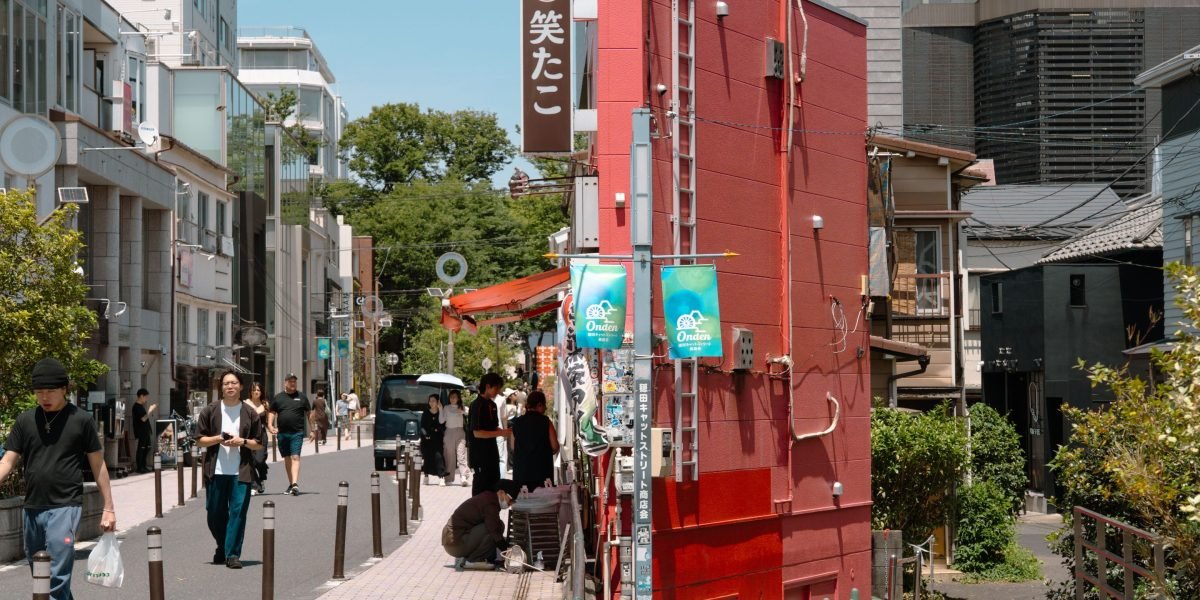 People walking and observing the surroundings in a vibrant, modern neighborhood, assessing its appeal and potential.
