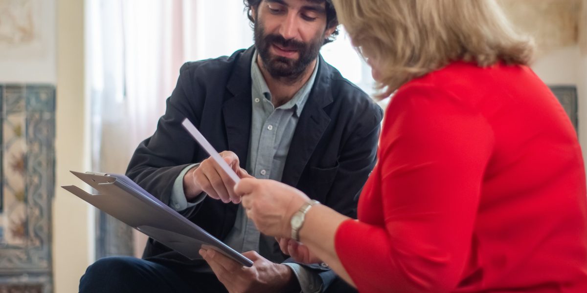 A real estate professional clearly explaining complex documents to a client, emphasizing transparency and trust in the broker-client relationship.