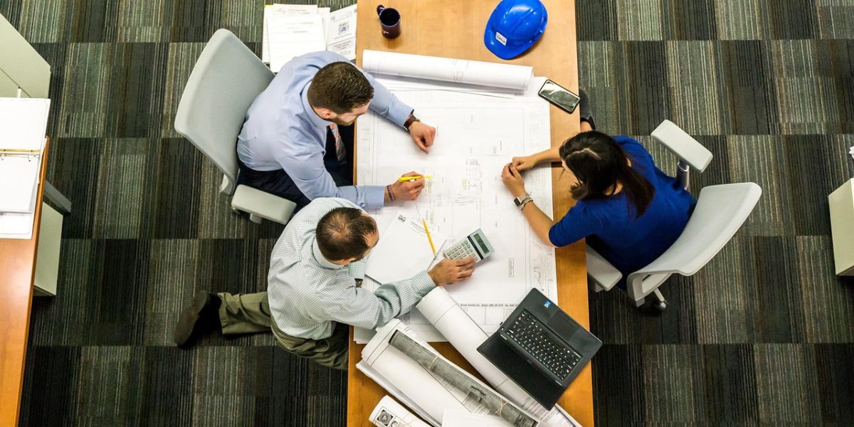 Business partners intently discussing investment strategy and market reports in an office setting.