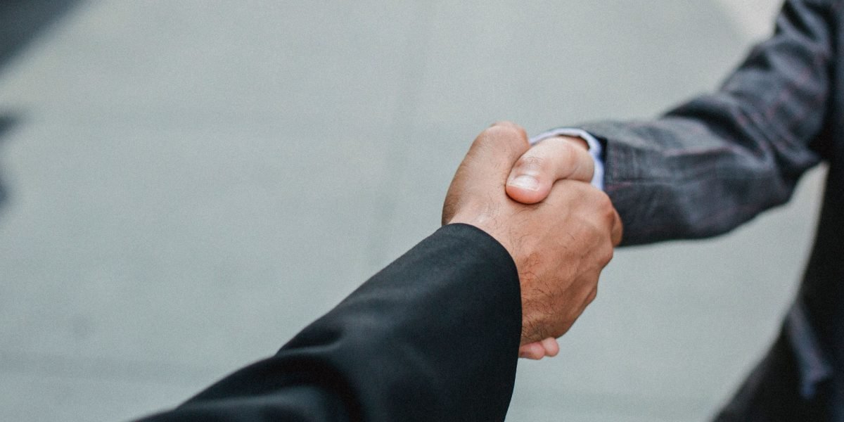 A handshake solidifies an agreement between professionals, a key moment in the property purchase process.