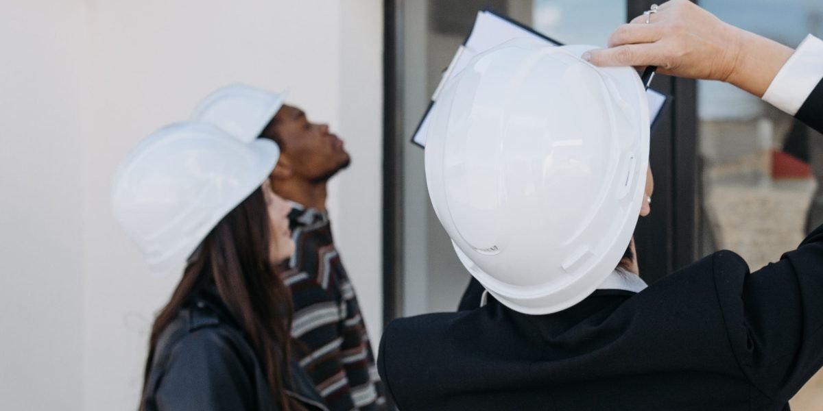 Buyers carefully examining blueprints or architectural plans for an off-plan property, highlighting due diligence.