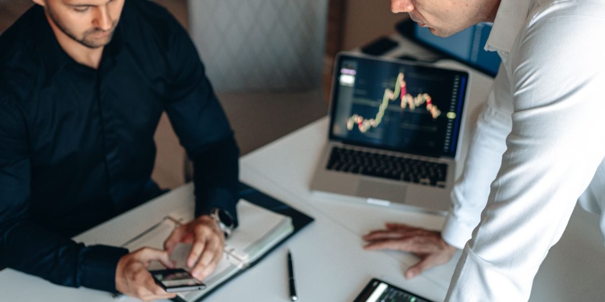 Real estate professionals analyze market trends and project developments on a large screen in an office.