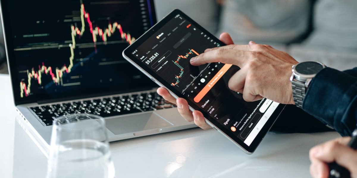 A person intently reviewing financial charts and market data, strategizing for property investment decisions.
